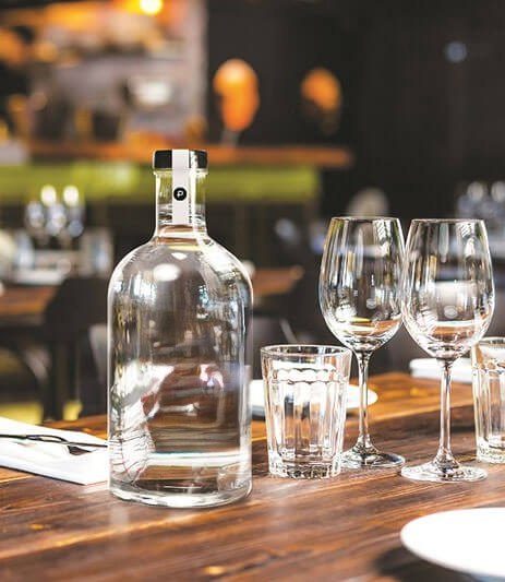 Carafe d'eau et verres sur une table de restaurant en bois